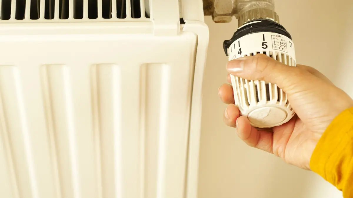 Hand turning a thermostatic radiator valve