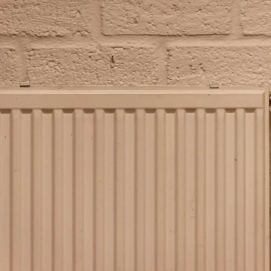 White panel radiator on a brick wall