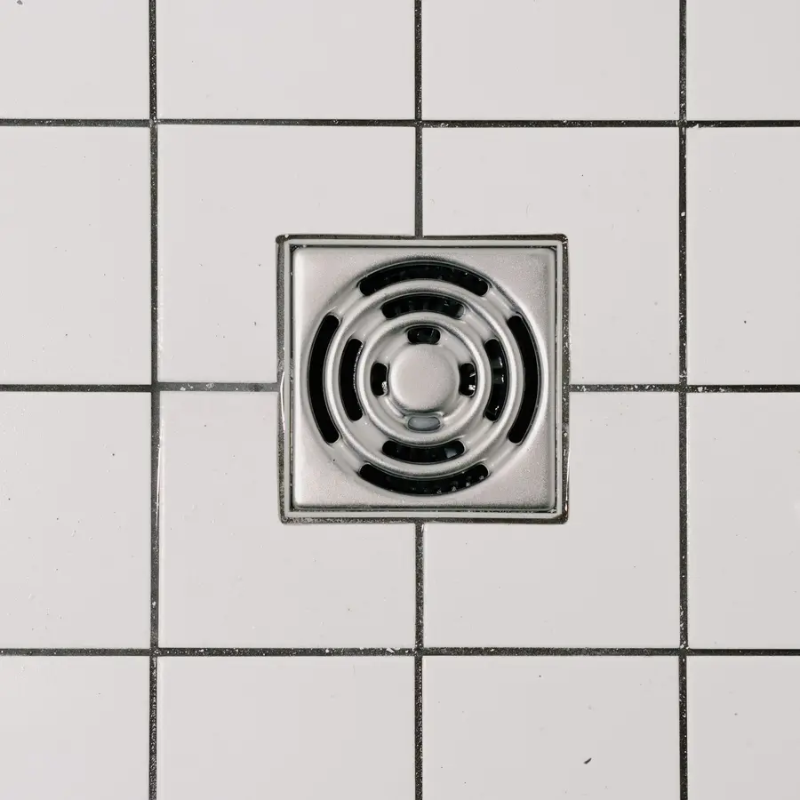 Stainless drain cover in a tiled shower